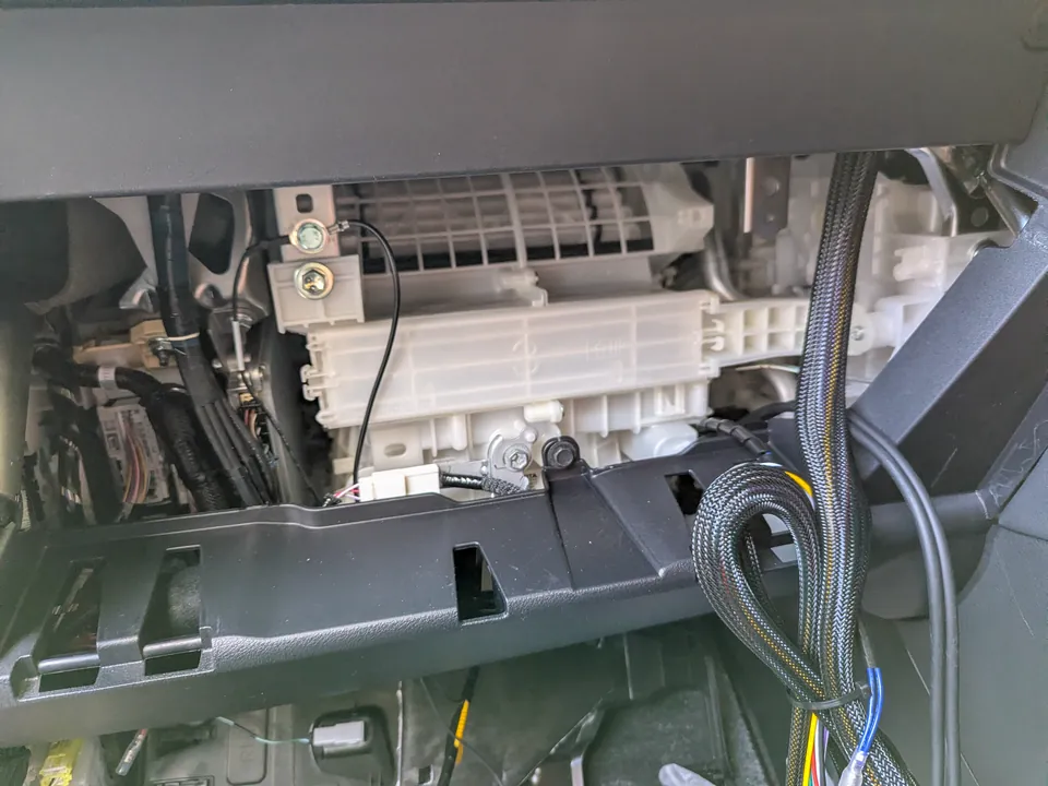 40系アルファードのグローブボックス奥にあるリーンホースメント。塗装のない金属露出部にボルト固定し、抵抗値$0.0\Omega$を実現したアースポイントの様子。