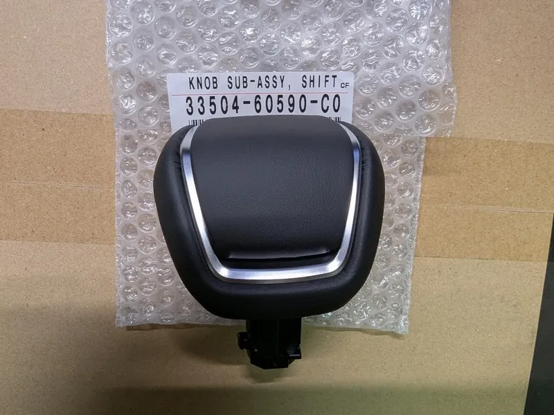ランドクルーザー300純正の本革仕様シフトノブ。黒の本革にシルバーの加飾パネルが組み合わされた高級感のある外観。