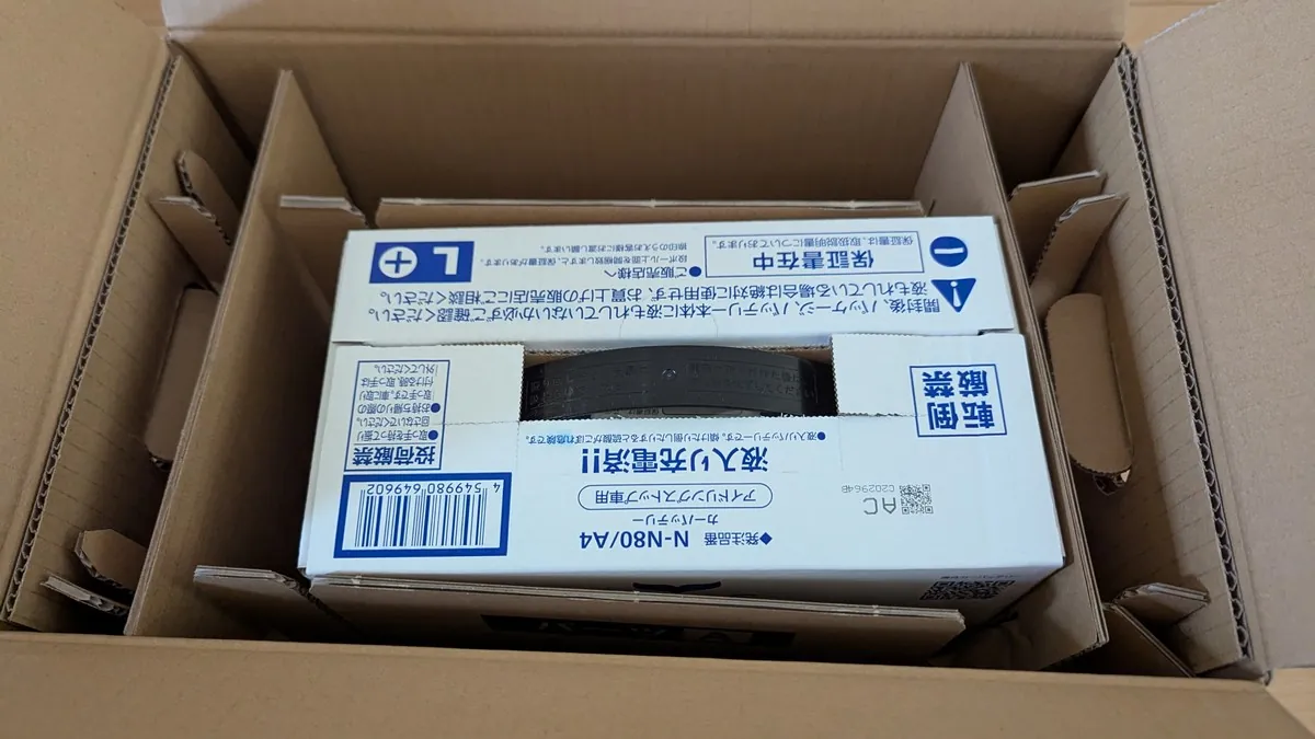 ネット通販で届いたパナソニック製カオスバッテリー(N-80)の梱包状態。液漏れや輸送中の衝撃による破損を防ぐため、バッテリーのメーカー外箱のさらに外側を、分厚く頑丈な段ボールでしっかりと覆った二重梱包が施されている。横倒し厳禁のステッカーも貼られており、安全に配慮して配送されたことが伝わるパッケージの写真。